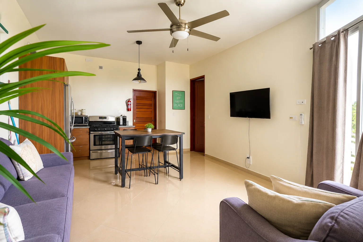 Spacious Suez living area with sofas, dining table and open kitchen