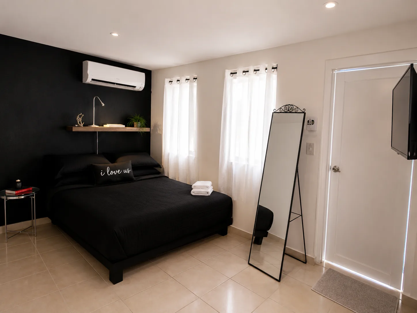 Gibraltar bedroom with queen bed and bright curtained windows