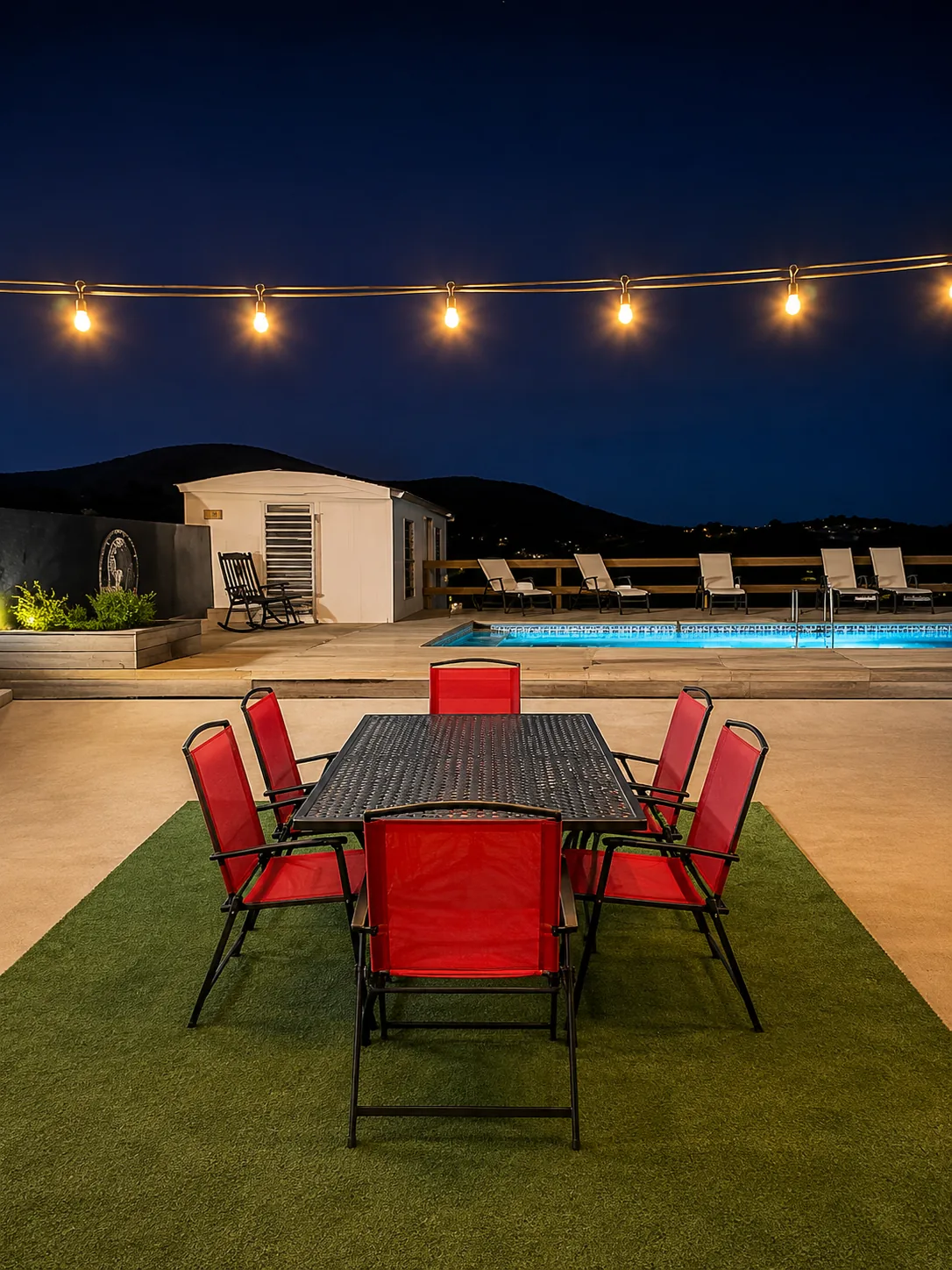 Casa Carmen backyard pool at night with outdoor dining