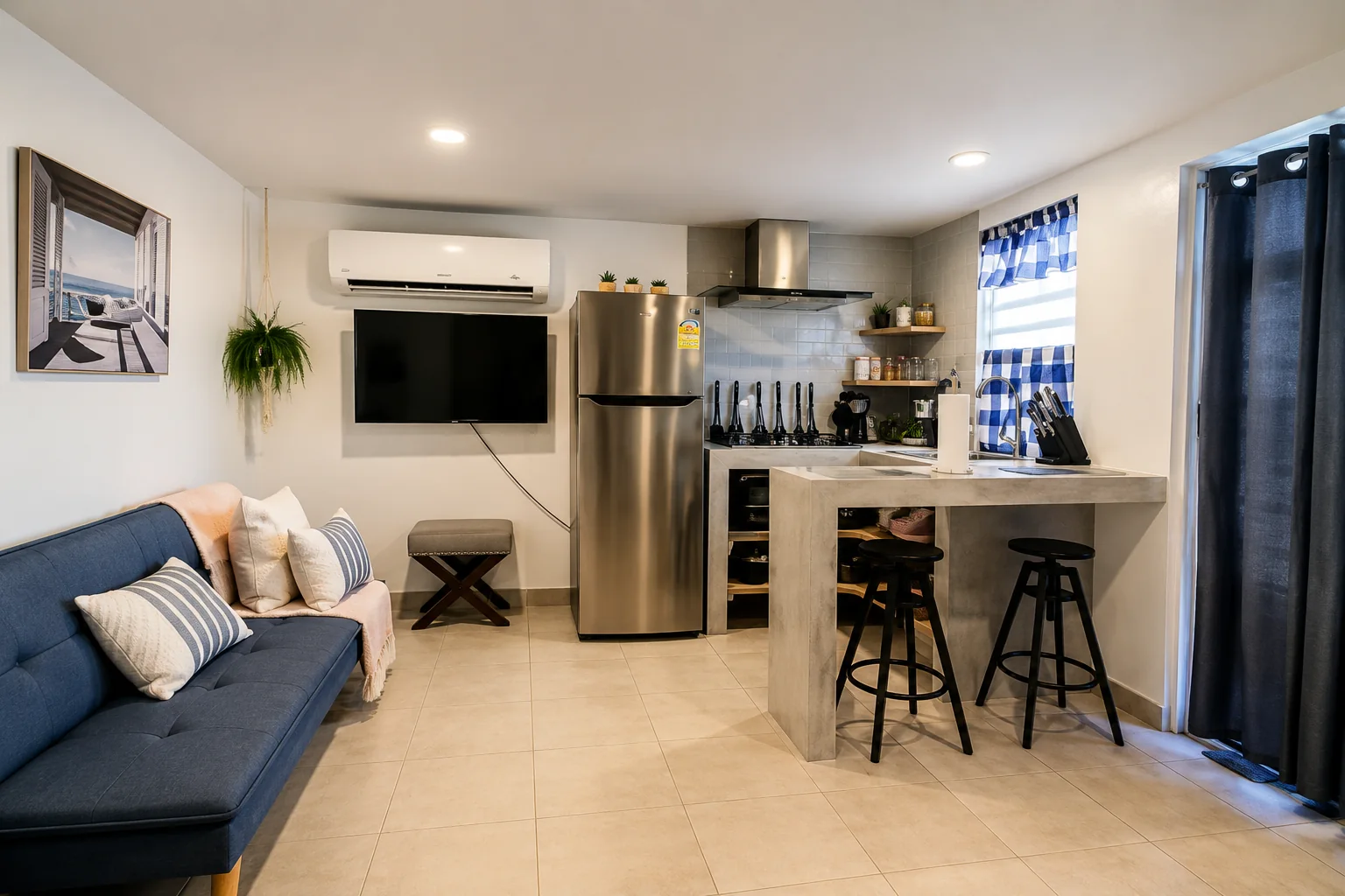 Cozy Rota living space with blue sofa, kitchen bar and stools